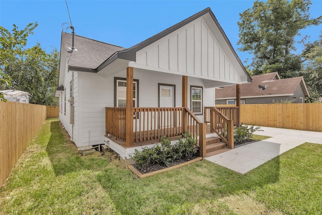 4412 Sayers St, Houston, TX 77026 - rear view of house featuring board and batten siding, roof with shingles, a fenced backyard, and a porch