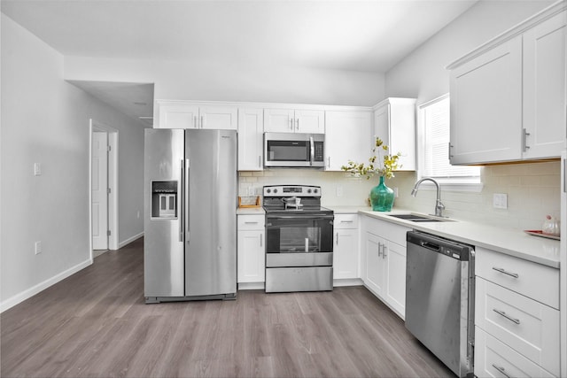 4412 Sayers St, Houston, TX 77026 - kitchen featuring stainless steel appliances, light wood finished floors, and white cabinetry