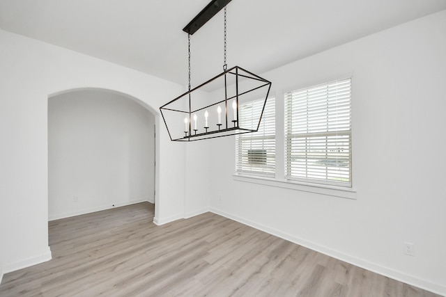 5318 Latigo Ct, Alvin, TX 77511 - unfurnished dining area with a chandelier, arched walkways, and light wood finished floors