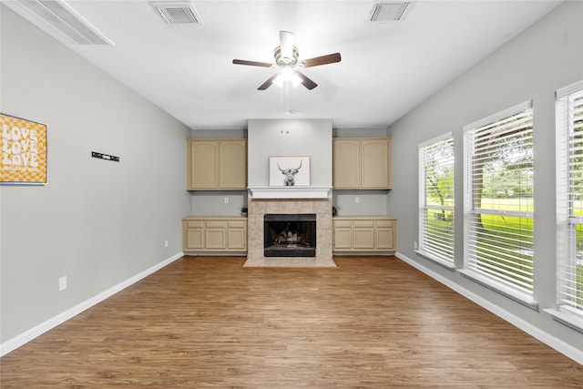 3327 Shady Glen Ln, Missouri City, TX 77459 - unfurnished living room featuring a ceiling fan, light wood-type flooring, and a tiled fireplace