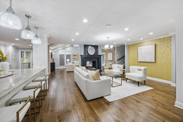 206 Lakemere St, Houston, TX 77079 - living room with wallpapered walls, a brick fireplace, dark wood finished floors, ornamental molding, and recessed lighting