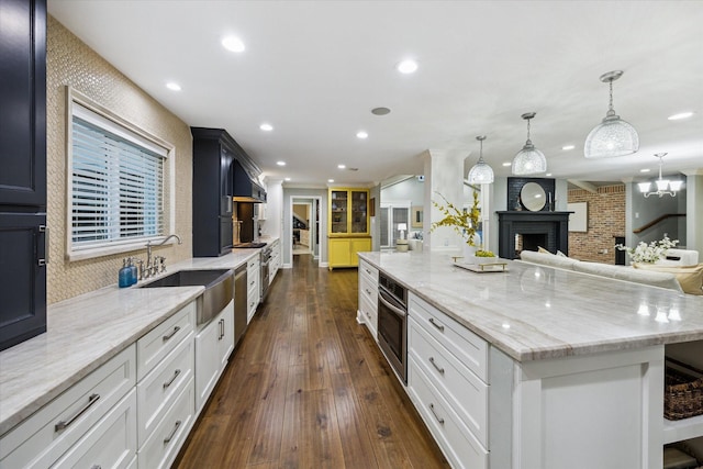 206 Lakemere St, Houston, TX 77079 - kitchen with stainless steel oven, light stone counters, dark wood-style flooring, a large island, and recessed lighting
