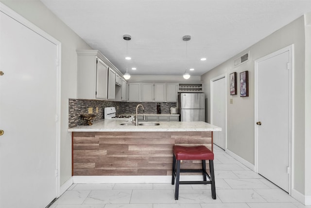 13530 Sharpbill Dr, Houston, TX 77083 - kitchen with freestanding refrigerator, light marble finish floors, a peninsula, white gas range, and light countertops