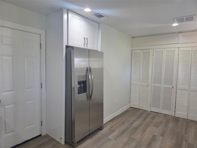 121 Tanglewood St, Baytown, TX 77520 - kitchen with stainless steel fridge with ice dispenser, wood finished floors, white cabinets, and recessed lighting