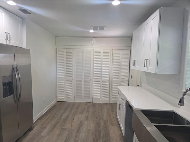 121 Tanglewood St, Baytown, TX 77520 - kitchen with appliances with stainless steel finishes, dark wood-type flooring, white cabinetry, and light countertops