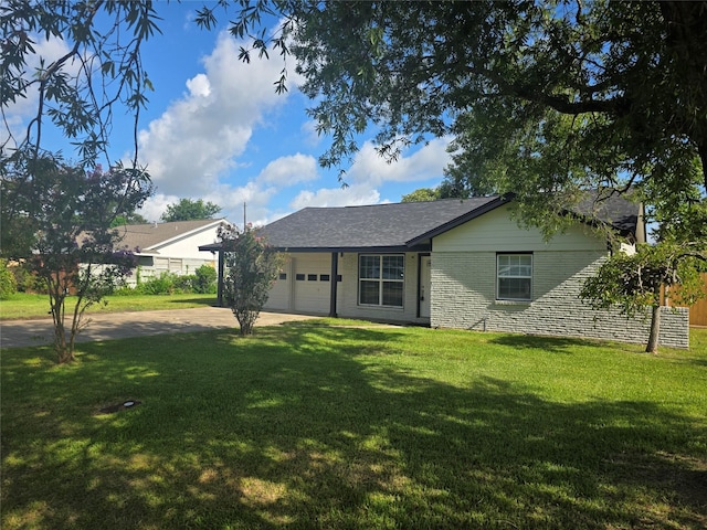 121 Tanglewood St, Baytown, TX 77520 - back of house featuring an attached garage, driveway, and a yard