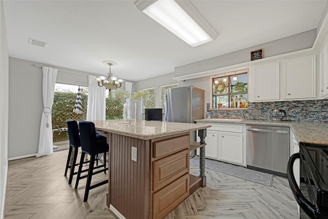 202 Old Bridge Lk, Houston, TX 77069 - kitchen featuring stainless steel appliances, a kitchen bar, a chandelier, a center island, and white cabinetry