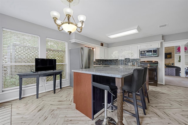 202 Old Bridge Lk, Houston, TX 77069 - kitchen featuring appliances with stainless steel finishes, white cabinetry, backsplash, a kitchen island, and a chandelier