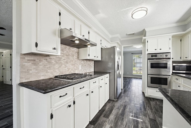 1804 Sleepy Creek Way, Pearland, TX 77581 - kitchen featuring appliances with stainless steel finishes, under cabinet range hood, a textured ceiling, crown molding, and dark wood-style flooring