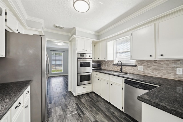 1804 Sleepy Creek Way, Pearland, TX 77581 - kitchen with stainless steel appliances, tasteful backsplash, white cabinets, a textured ceiling, and ornamental molding