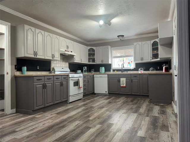 308 S 11th St, La Porte, TX 77571 - kitchen with white appliances, gray cabinets, under cabinet range hood, ornamental molding, and glass insert cabinets
