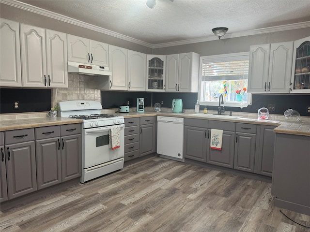 308 S 11th St, La Porte, TX 77571 - kitchen featuring white appliances, gray cabinetry, under cabinet range hood, a textured ceiling, and glass insert cabinets