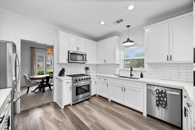 16235 Salmon Ln, Spring, TX 77379 - kitchen featuring stainless steel appliances, ornamental molding, healthy amount of natural light, light countertops, and recessed lighting