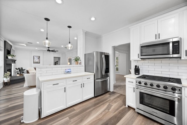 16235 Salmon Ln, Spring, TX 77379 - kitchen with appliances with stainless steel finishes, a peninsula, recessed lighting, light countertops, and wood finished floors