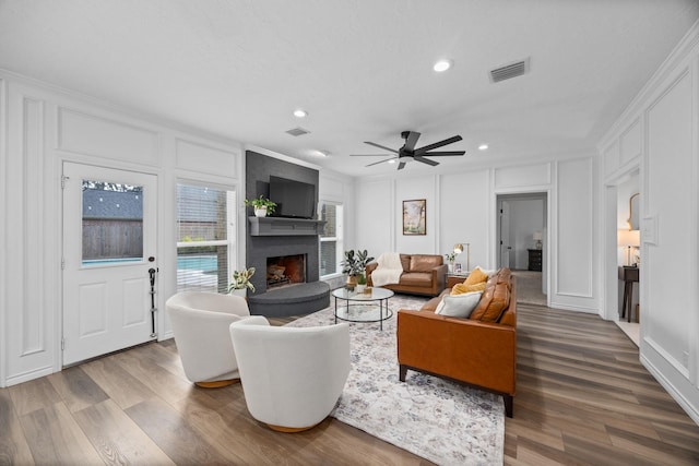 16235 Salmon Ln, Spring, TX 77379 - living area with a decorative wall, a fireplace, recessed lighting, wood finished floors, and a ceiling fan