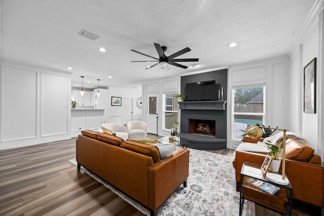 16235 Salmon Ln, Spring, TX 77379 - living room with a decorative wall, crown molding, a brick fireplace, wood finished floors, and a ceiling fan