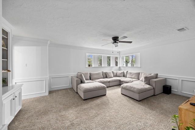 16235 Salmon Ln, Spring, TX 77379 - carpeted living room with a decorative wall, ornamental molding, a ceiling fan, a textured ceiling, and a wainscoted wall