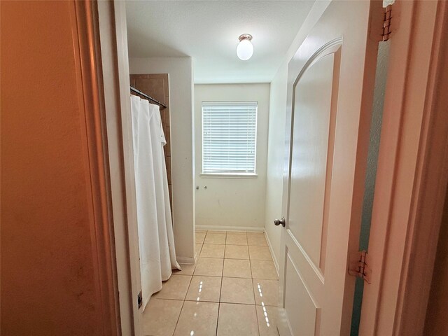 9458 Grand Spark Dr, Rosharon, TX 77583 - hallway featuring light tile patterned floors and baseboards