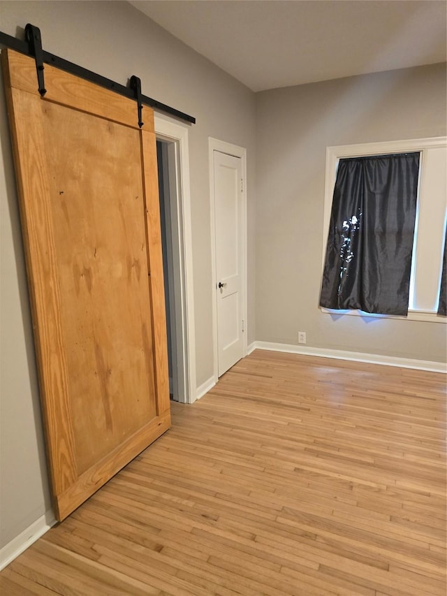 604 N Main St, Galena Park, TX 77547 - unfurnished bedroom featuring light wood finished floors and a barn door