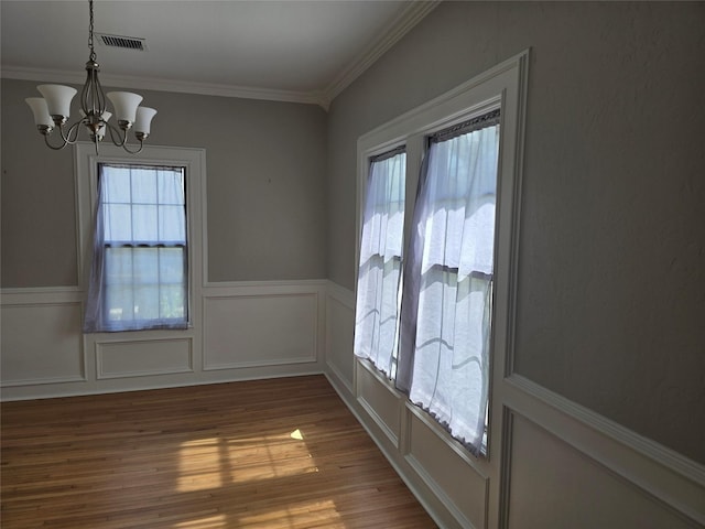 604 N Main St, Galena Park, TX 77547 - spare room with a chandelier, wainscoting, wood finished floors, ornamental molding, and a decorative wall