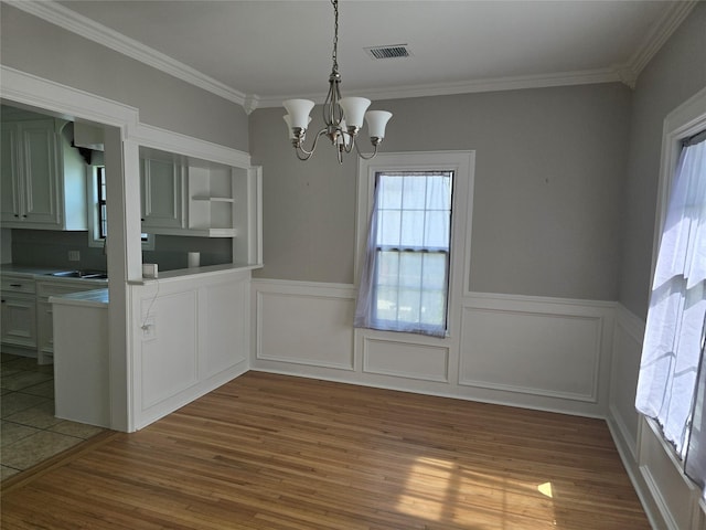 604 N Main St, Galena Park, TX 77547 - unfurnished dining area with a chandelier, wood finished floors, crown molding, and wainscoting