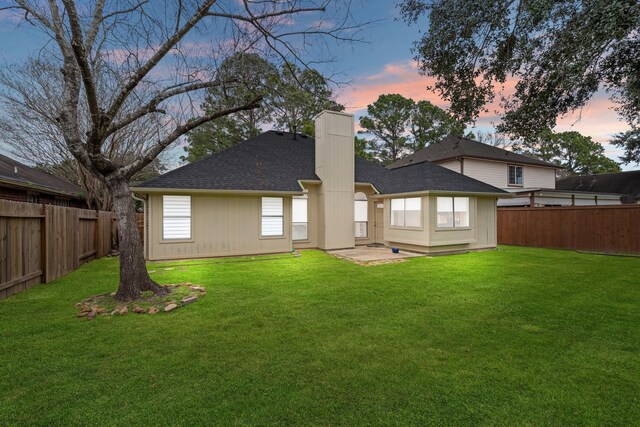 22731 Willhanna Dr, Katy, TX 77449 - back of property at dusk with a fenced backyard, a chimney, and roof with shingles