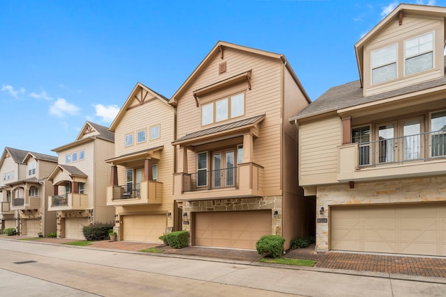 2623 Shady Woods Ln, Houston, TX 77008 - view of front facade featuring stone siding, an attached garage, decorative driveway, a balcony, and a residential view