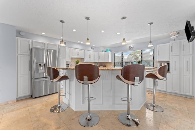 2816 Lighthouse Dr, Houston, TX 77058 - kitchen featuring stainless steel fridge with ice dispenser, decorative backsplash, white cabinets, recessed lighting, and a textured ceiling