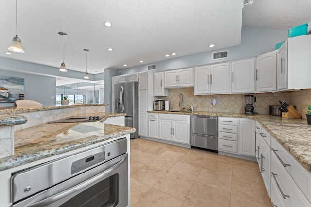 2816 Lighthouse Dr, Houston, TX 77058 - kitchen with appliances with stainless steel finishes, backsplash, white cabinetry, decorative light fixtures, and recessed lighting