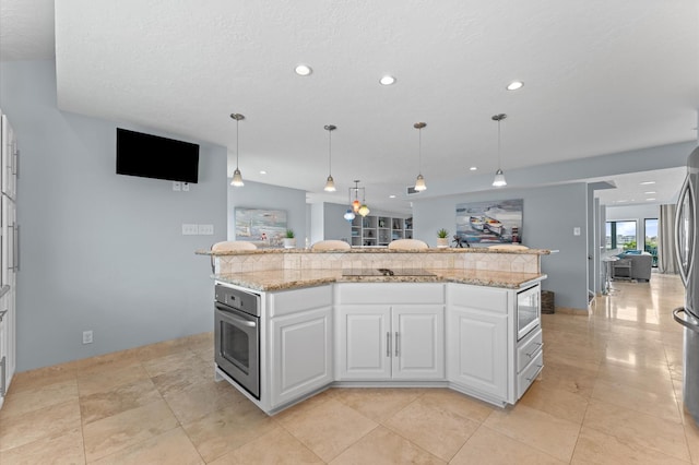 2816 Lighthouse Dr, Houston, TX 77058 - kitchen featuring appliances with stainless steel finishes, white cabinetry, recessed lighting, light stone counters, and pendant lighting