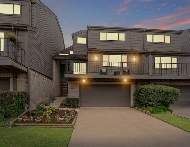 2816 Lighthouse Dr, Houston, TX 77058 - view of front of property with concrete driveway, a garage, brick siding, stairway, and a balcony