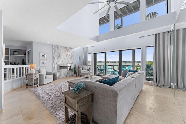 2816 Lighthouse Dr, Houston, TX 77058 - living room featuring ceiling fan, a towering ceiling, a fireplace, built in features, and a water view