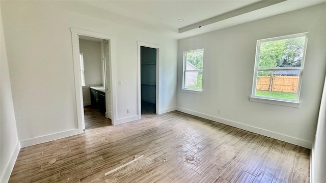 2418 Centennial St, Liberty, TX 77575 - unfurnished bedroom featuring a walk in closet, wood finished floors, and connected bathroom