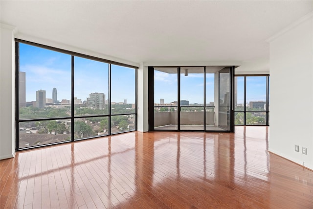 1111 Bering Dr Unit 1001, Houston, TX 77057 - unfurnished room with floor to ceiling windows, hardwood / wood-style flooring, and a skyline view