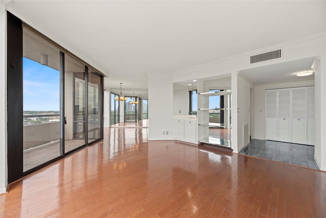 1111 Bering Dr Unit 1001, Houston, TX 77057 - spare room featuring wood finished floors, a chandelier, crown molding, and floor to ceiling windows