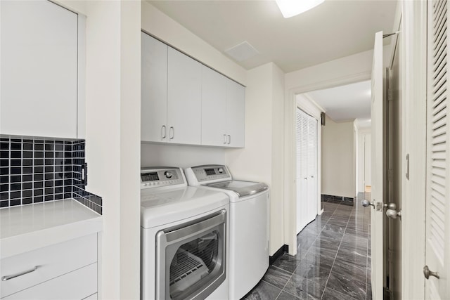 1111 Bering Dr Unit 1001, Houston, TX 77057 - laundry room featuring dark marble finish flooring, cabinet space, and separate washer and dryer