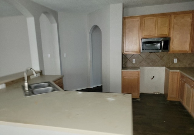 3301 Clover Hill Ln, Texas City, TX 77591 - kitchen with stainless steel microwave, arched walkways, backsplash, and light countertops