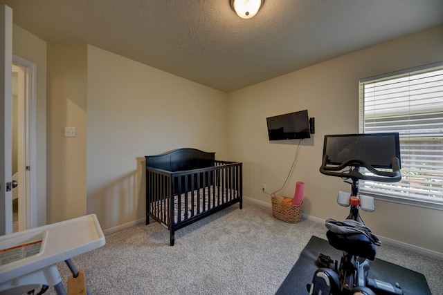 1009 Old Vine, Brenham, TX 77833 - bedroom featuring carpet flooring, a textured ceiling, and a crib