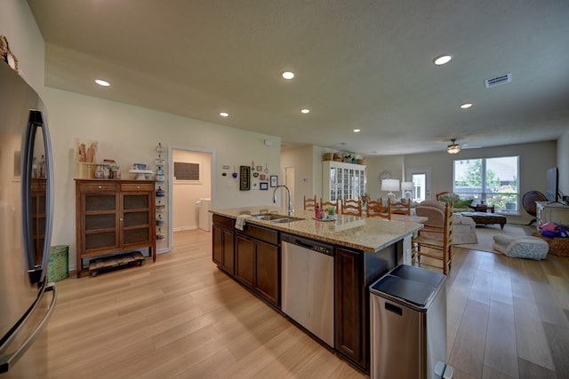 1009 Old Vine, Brenham, TX 77833 - kitchen with dishwasher, freestanding refrigerator, light wood finished floors, recessed lighting, and dark brown cabinets