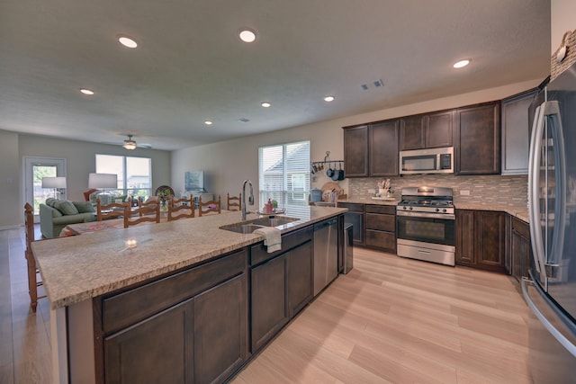 1009 Old Vine, Brenham, TX 77833 - kitchen with stainless steel appliances, recessed lighting, dark brown cabinetry, light wood-type flooring, and backsplash
