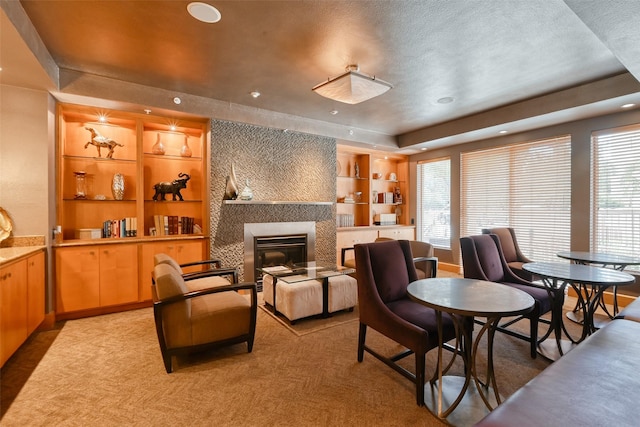3505 Sage Rd Unit 1206, Houston, TX 77056 - living room featuring a tile fireplace, recessed lighting, built in features, a tray ceiling, and light carpet