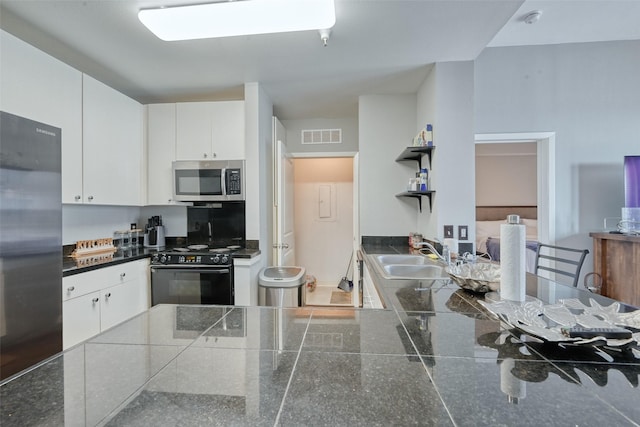 3505 Sage Rd Unit 1206, Houston, TX 77056 - kitchen with stainless steel appliances, dark countertops, white cabinetry, and open shelves