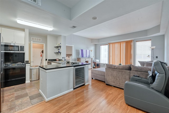 3505 Sage Rd Unit 1206, Houston, TX 77056 - kitchen with beverage cooler, dark countertops, white cabinets, open floor plan, and stainless steel microwave