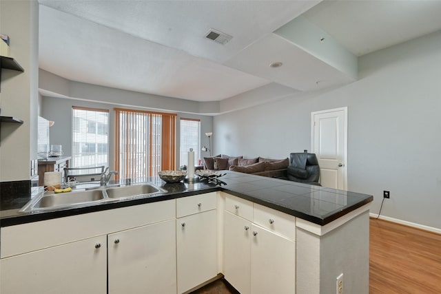 3505 Sage Rd Unit 1206, Houston, TX 77056 - kitchen with open floor plan, a peninsula, wood finished floors, open shelves, and white cabinets