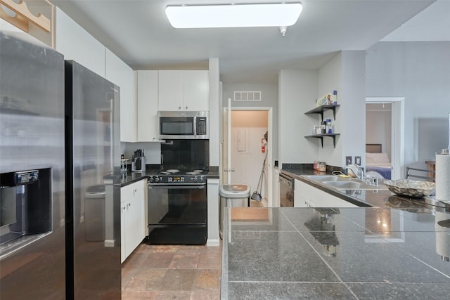 3505 Sage Rd Unit 1206, Houston, TX 77056 - kitchen featuring stainless steel appliances, dark countertops, open shelves, white cabinetry, and stone finish flooring