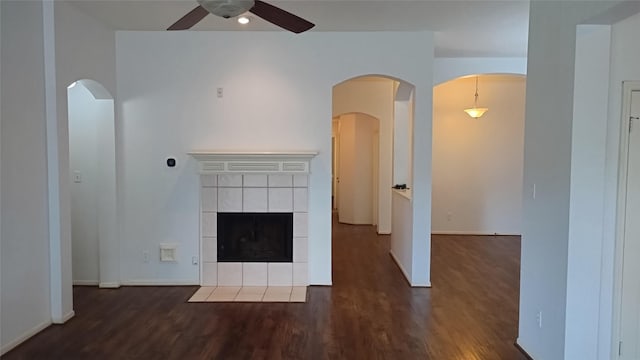 11718 Emerald Wood Dr, Houston, TX 77070 - unfurnished living room featuring ceiling fan, wood finished floors, a tile fireplace, and arched walkways