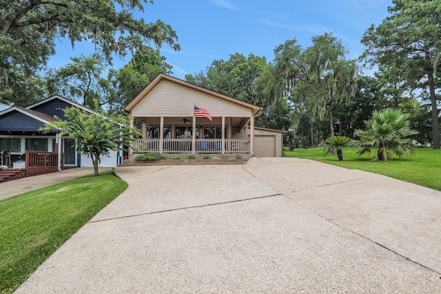 63 Harbour Row Dr, Coldspring, TX 77331 - view of front facade featuring covered porch, driveway, a front lawn, and an attached garage