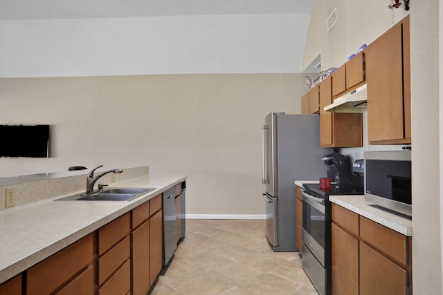 63 Harbour Row Dr, Coldspring, TX 77331 - kitchen featuring appliances with stainless steel finishes, under cabinet range hood, light countertops, light tile patterned floors, and brown cabinets