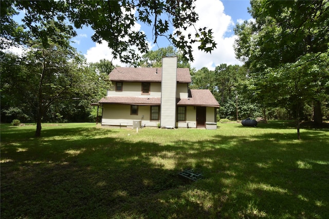 191 Harvey Bryant Rd, Coldspring, TX 77331 - rear view of property featuring a lawn and a chimney