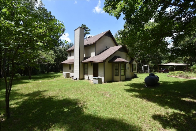 191 Harvey Bryant Rd, Coldspring, TX 77331 - rear view of property with a chimney, a lawn, and a shingled roof